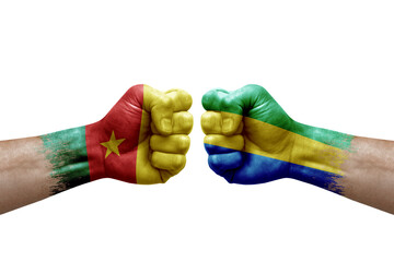 Two hands punch to each others on white background. Country flags painted fists, conflict crisis concept between cameroon and gabon