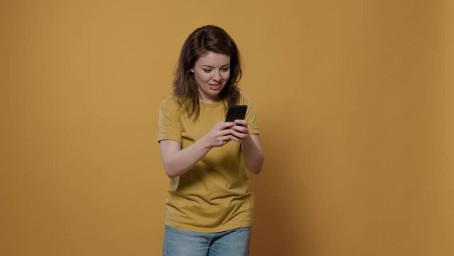Portrait of woman holding smartphone looking at touchscreen texting friend recieving extraordinary good news wanting to jump for joy. Smiling person using mobile phone overwhelmed with happiness.