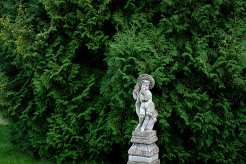 Obraz premium statue of a boy with grapes in a garden 