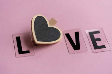 letras formando la palabra LOVE con un corazón en el centro y fondo rosado