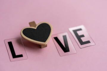 letras formando la palabra LOVE con un corazón en el centro y fondo rosado