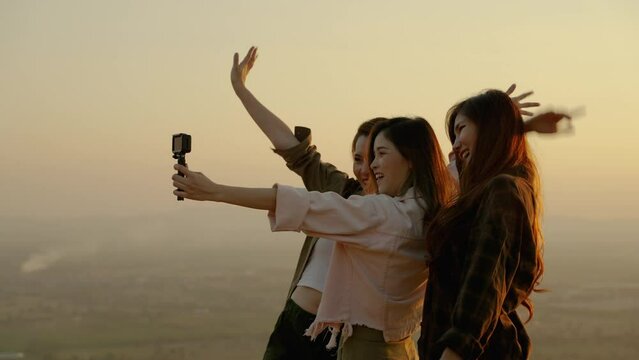 girl friend group Asians blogger standing and caper enjoying the beauty of nature in the evening sunset and shoot video from their action cams to show off to their friends in social media,freedom conc