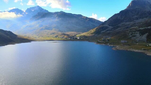 Drone flight over Lago die Montespluga with view on city at sunset
