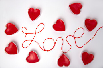 Text love and red candle hearts around the word. Romance. February 14 Valentine's Day