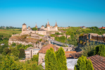 Fototapeta na wymiar View of the ancient Kamianets Podilskyi Castle with townscape of buildings and trees. Beautiful view of castle.