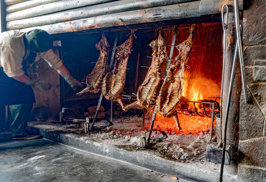 Argentina, Patagonia, traditional lamb barbecue (assado)  on an open fire place.