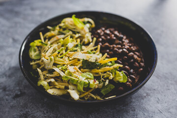 vegan nourish bowl with black beans and mixed greens, healthy plant-based food