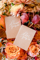 His and Hers vow books resting on colorful wedding flowers