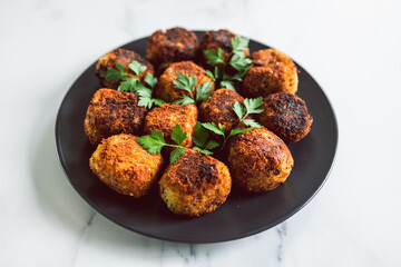 vegan pesto arancini fried risotto balls with fresh parsley as topping, healthy plant-based food