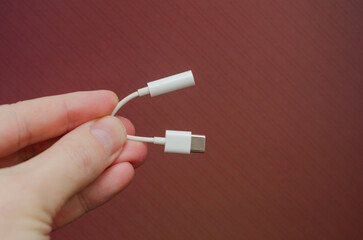 usb type-c to audio 3.5 adapter cable in male hand