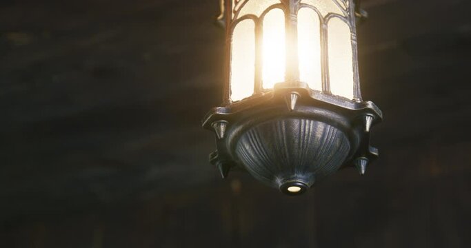 Bright lantern hangs on ceiling swinging at rolling OF pirate ship and illuminating cabin with light close low angle shot