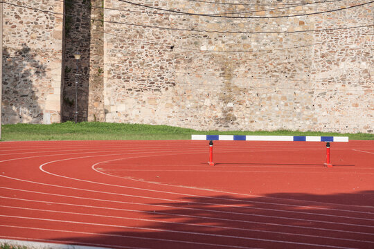Selective blur on the curve on a running track, with a hurdle used for hurdling om an athletics field used for athletism competition, like sprint, or running race, and for competitive events. ..