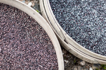 Close-up of raw cochineal in baskets on a grassy background.
