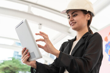 Engineer Worker Wearing Hard Hat Uses Tablet Computer. Happy Successful. Businesswomen working with tablet checklist. woman working.