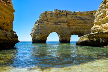 Fototapeta na wymiar Ocean beach, cliffs and craved arches by ocean and wind forces. Coastal landscape, Atlantic ocean, Algarve south Portugal. 