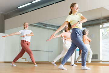Obraz premium Girl dancing with her relatives during group aerobic training.