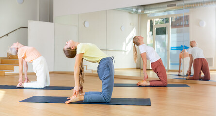 Active teenager girl exercising stretching workout and incline during yoga class in fitness studio