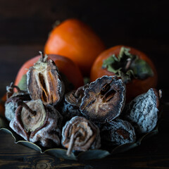 Dried persimmon and fresh persimmon on a wooden background. Healthy diet. Healthy diet