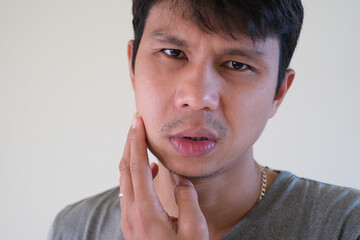 Teetch problem. Asian male with painful cheek swelling or dental abscess. A facial injury, tooth abscess, salivary stones, salivary gland tumor. - obrazy, fototapety, plakaty