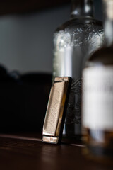 A shallow focus shot of a harmonica and glass bottles