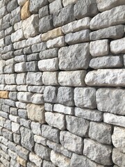 Perspective view of decorative natural cobble stone wall with different shades of grey and sizes, shadow gap. Natural texture and form. Exterior wall covering.