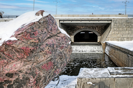 View of the spillway of the city pond dam on a winter day