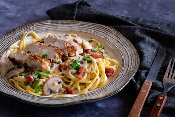 Close up of a plate of chicken carbonara ready for eating.