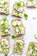 Light and airy cucumber and radish tartines with copy space to the right.