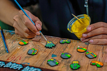 Craft pins made of acrylic and colored using enamel paint, all done manually in a home workshop