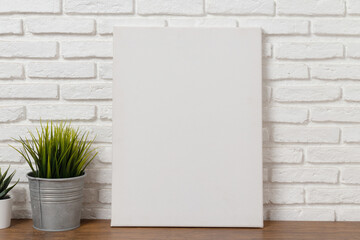 blank white canvas frame on a wooden table