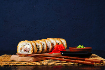 Fried tempura sushi rolls set selective focus with copy space. Japanese traditional fusion food...