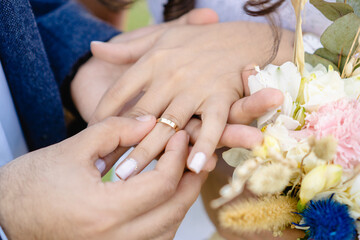 groom putting wedding ring on bride, close up