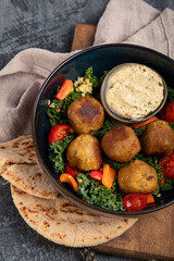 Falafel with hummus on dark background.