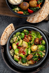 Brussel sprout salad with bulgur on dark background.