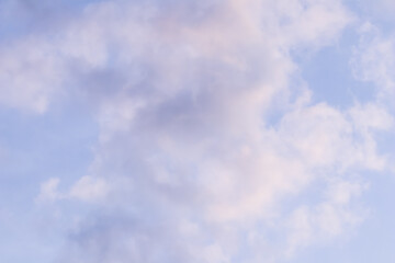 Background of blue sky with white pink clouds at sunset