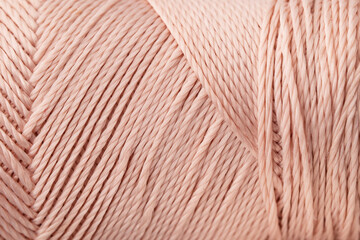Macro texture of bright coral silk thread, close-up, copy space. Macro Photography of a coil with threads. Sewing background, screensaver. Abstraction, interweaving of shiny threads