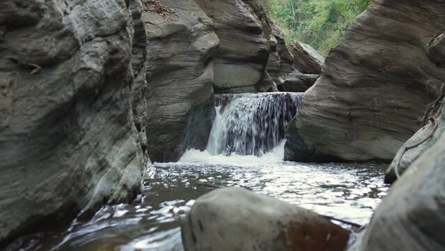Close-up shot of a waterfall cascading down a rock in slow motion, laterite palace, Pua Nan.