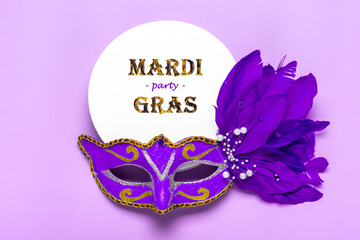 Mardi gras lettering. Congratulation card with mask on white podium on violet background Top view...