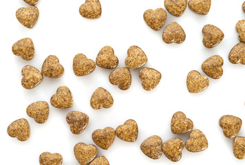 brown pills in the shape of a heart close-up in a jar on a white background. The concept of treatment of cardiovascular diseases.