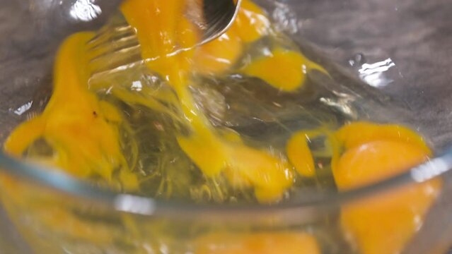 Mixing Eggs with a Fork, Making Scrambled Eggs in a Glass Bowl, Mixing Egg Yolk and White