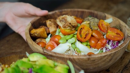 Close up of human hands serving two big appetizing vegetable bowls with fresh healthy vegan products