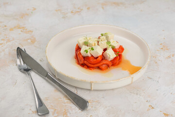 salad with peppers and cheese in a white plate with cutlery

