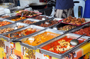 Malaysian traditional Malay cuisine is on display for sale at roadside stalls. Rich in spices and...