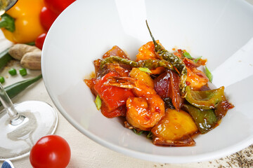 dish of indian cuisine shrimp in sauce with sweet pepper on a white background close-up
