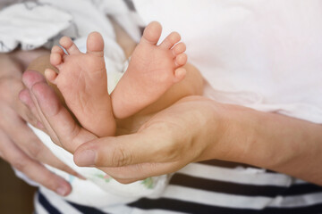 Fototapeta na wymiar Baby feet on mother's hand with love