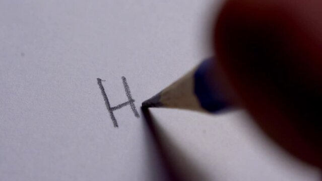 Hand writing hello on white paper sheet