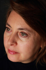 Portrait of a middle aged woman on a black background.