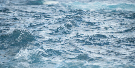 Fototapeta na wymiar Calm sea water surface texture with splashes and waves. Abstract nature background. Background of aqua ocean water surface.