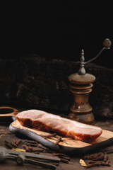 Spicy smoked ham dish or bacon requires preparation at home, with a smoker, a handmade wood cutting board, and a bone in roast