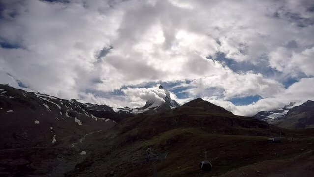 Accelerated clouds swirl over the mountain peak